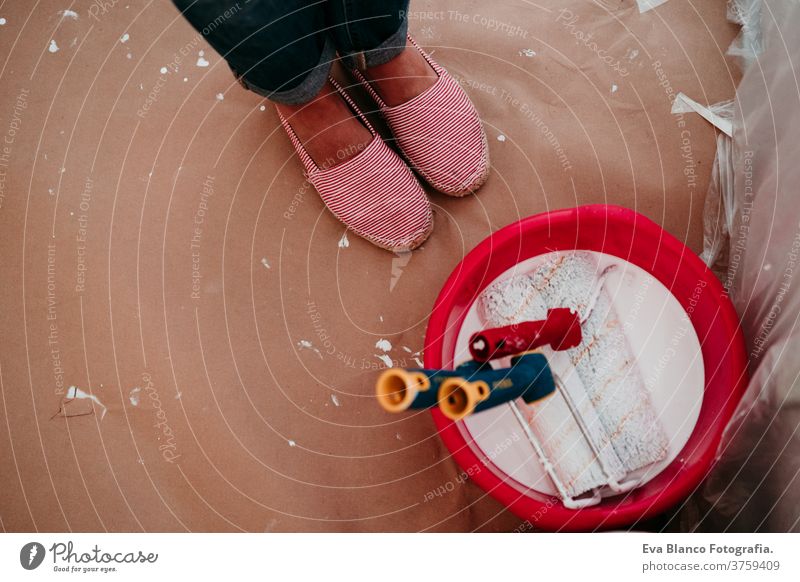 top view of woman ready to paint the room walls with white color. Do it yourself and new home concept painting bucket move close up hands unrecognizable holding