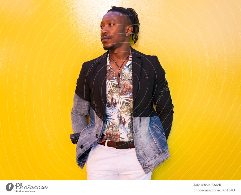 Confident ethnic man in stylish wear in city model fancy style apparel vivid yellow wall trendy male black african american fashion outfit urban confident