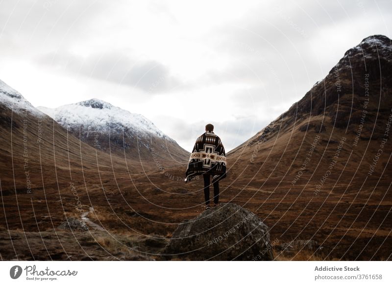 Traveling man on stone in highland valley mountain traveler explore wanderlust enjoy fall season male scottish highlands scotland uk united kingdom explorer