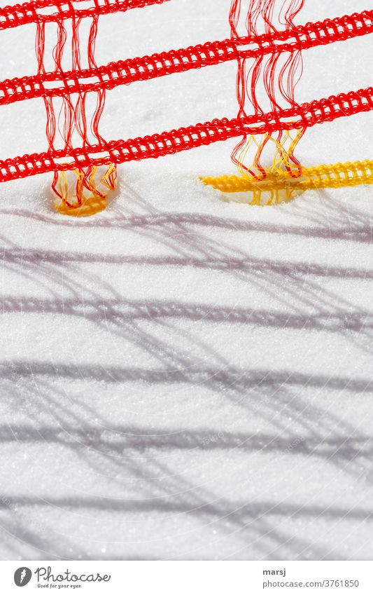 Barrier fence made of red and yellow plastic, on the ski slope Snow wickerwork Plaited cordon Shadow play Red Yellow Gaudy Plastic Structures and shapes Detail