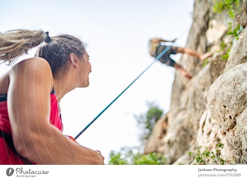 Climber securing another climber going down climbers climbing rock go down lifestyle descending secure man active activity adrenaline algarve cliff exercise