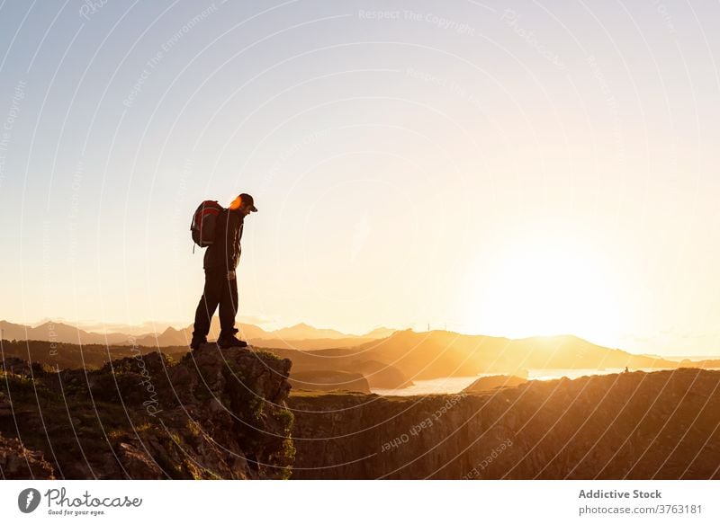 Unrecognizable traveling man on hill at sunset hiker backpack mountain admire vacation sundown trekking male rock amazing relax chill adventure scenic landscape