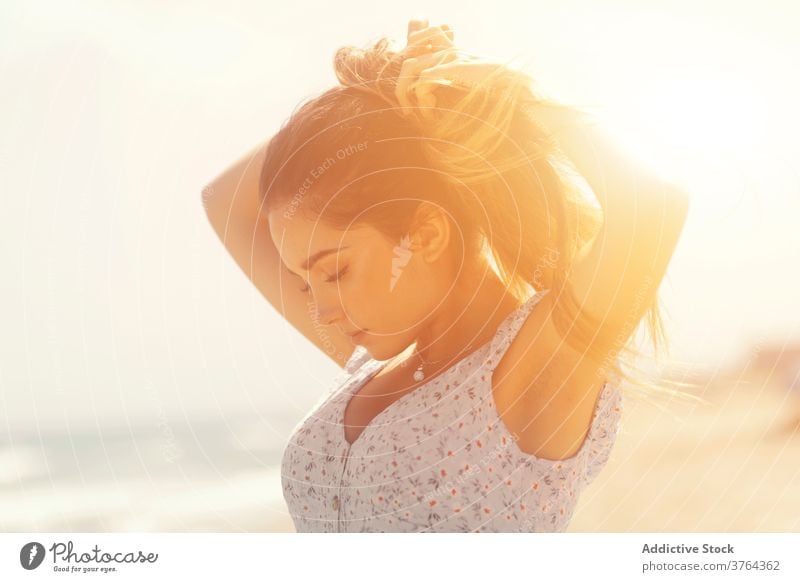 Sensual woman standing on sunny seashore beach sensual sunlight dress charming gentle pure calm tranquil relax elegant feminine young female spain valencia