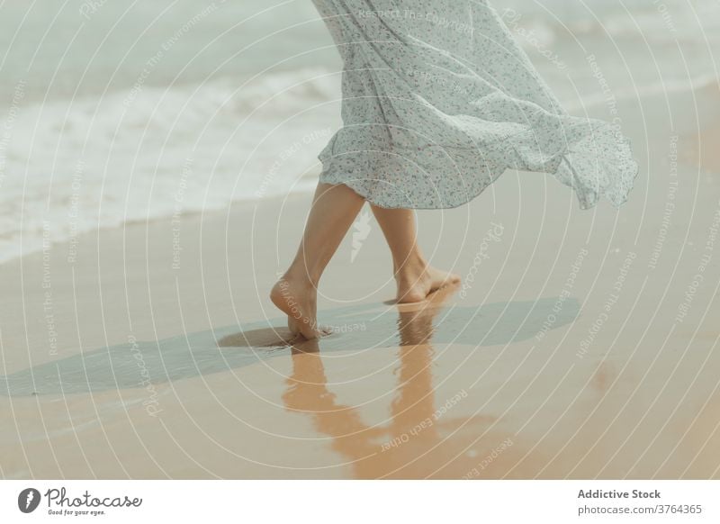 Anonymous woman in dress walking on sandy beach barefoot leg shore coast alone pure sea gentle female spain valencia el saler beach nature romantic freedom