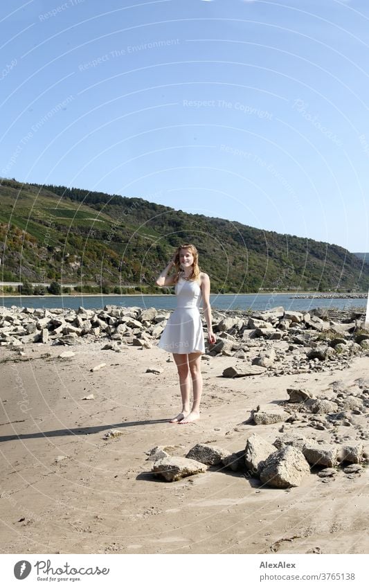 Backlit portrait of a young, barefoot woman on the banks of the Rhine Woman Young woman Slim already athletic Blonde youthful 18-25 years red blonde hair look