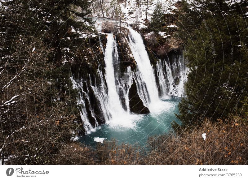 Waterfall in snowy mountainous forest in winter day waterfall flow nature landscape pool cold stream scenic picturesque scenery travel tourism usa united states