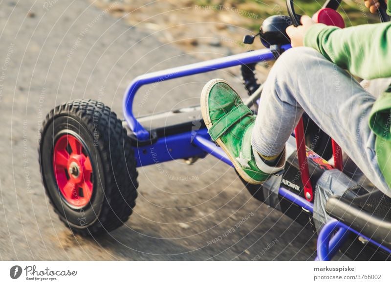 Boy with vintage retro kettcar Boy (child) Retro Tracked car Playing Playground Vehicle quad Impulsion Feet leg Force Steering wheel Infancy Adventure