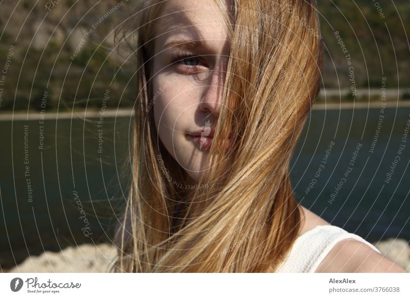 Close portrait of a young woman with wind-blown hair in a white dress in front of the Rhine bank Woman Young woman Slim already athletic Blonde youthful