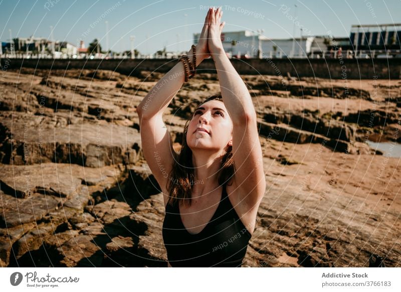 Woman practicing yoga on rocky beach namaste woman pose practice asana summer pray gesture female calm harmony peaceful wellness serene concentrate zen nature