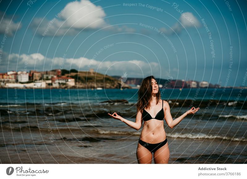 Slender woman doing yoga on the beach asana practice slim tranquil seashore bikini female amazing seascape wellness peaceful zen posture nature wellbeing