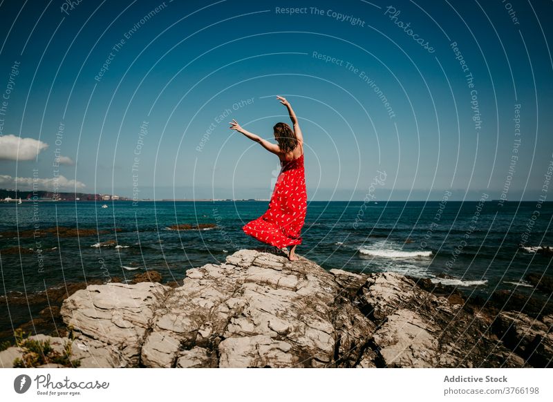 Graceful woman in dress on rocky hill grace red balance tender delight move slim female barefoot rough blue sky cloudless heaven nature serene sensual freedom