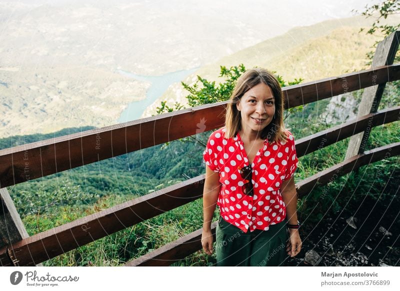 Young female nature explorer enjoying the view from mountain viewpoint lake adult adventure alone background beautiful casual caucasian destination environment