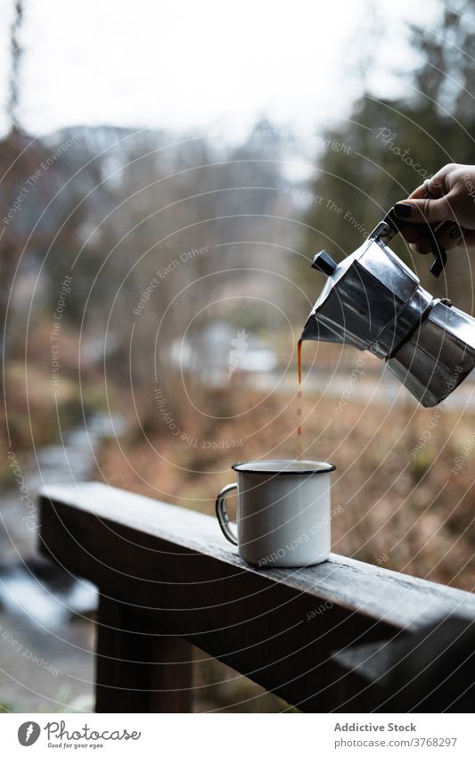 Traveler pouring hot coffee into mug in autumn nature travel enamel hot drink break rest together countryside beverage cup relax trip journey warm season