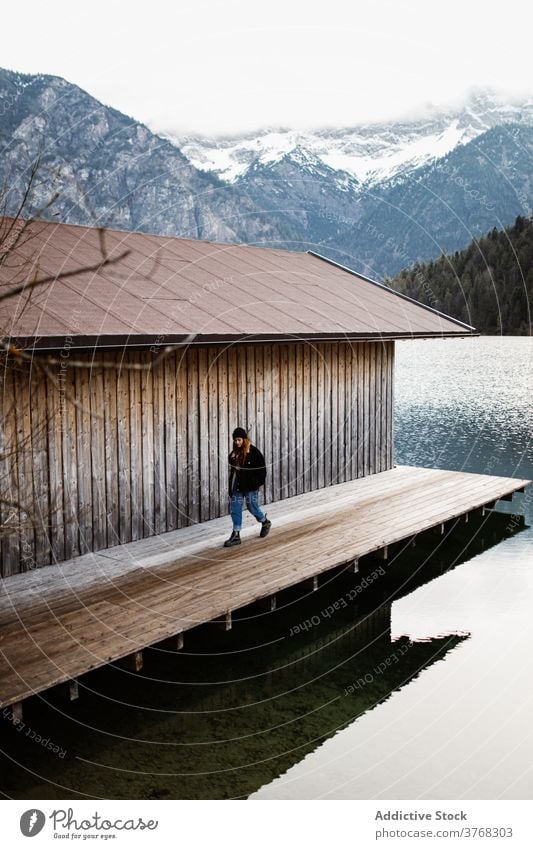 Woman walking on wooden pier near lake mountain traveler woman wanderlust relax solitude highland reflection pond female germany austria quay scenery calm