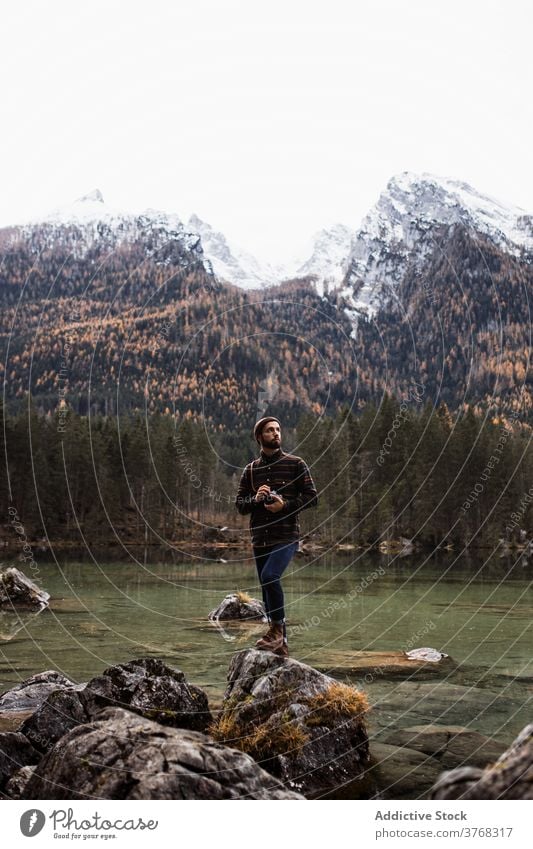 Photographer taking photos of nature near lake man photo camera autumn photographer travel take photo shore shot mountain journey adventure young photography