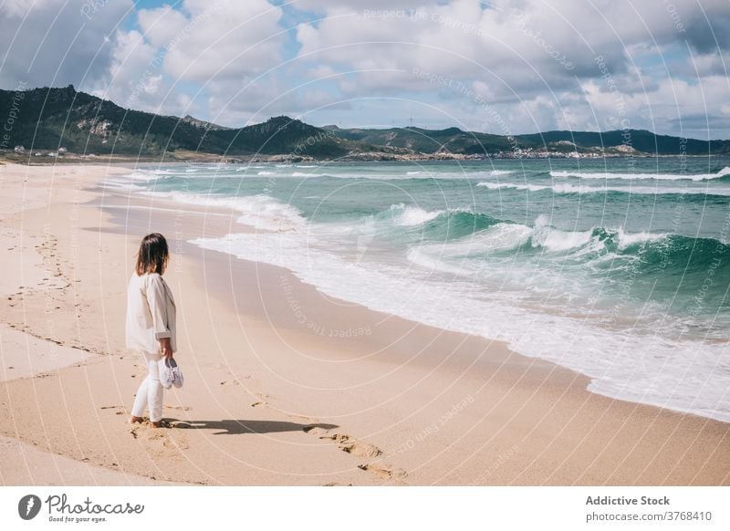 Woman admiring waving sea on beach woman wave sand fresh stormy alone seaside shore female travel tourism spain barefoot enjoy relax recreation breeze summer