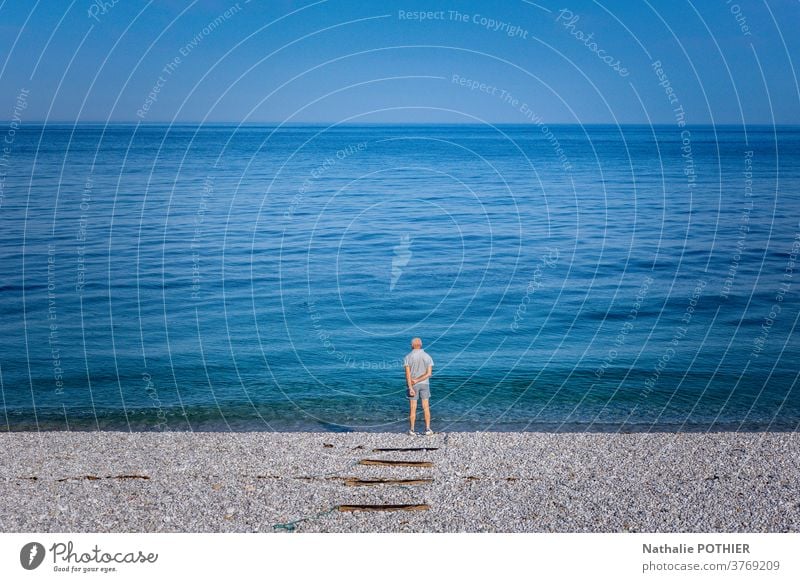 Lonely man on beach looking the horizon landscape sea ocean alone watching blue sky blue sea standing nature view outdoor background water travel people person