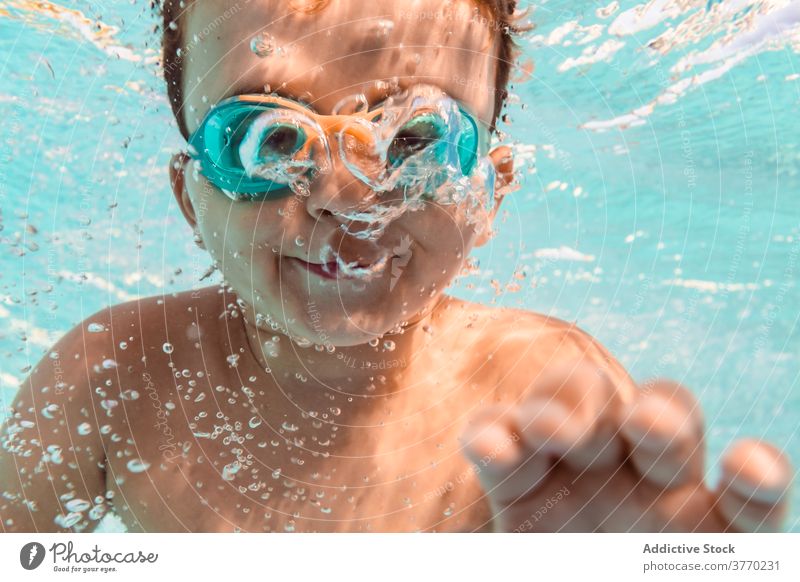 Happy child in swimming pool boy summer having fun goggles clean water weekend kid positive childhood relax resort joy aqua recreation happy activity playful