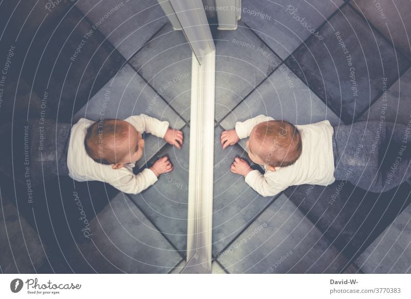 Baby looks at himself in the mirror Mirror image look at inquisitorial Toddler spellbound Cute Enthusiasm Observe explore