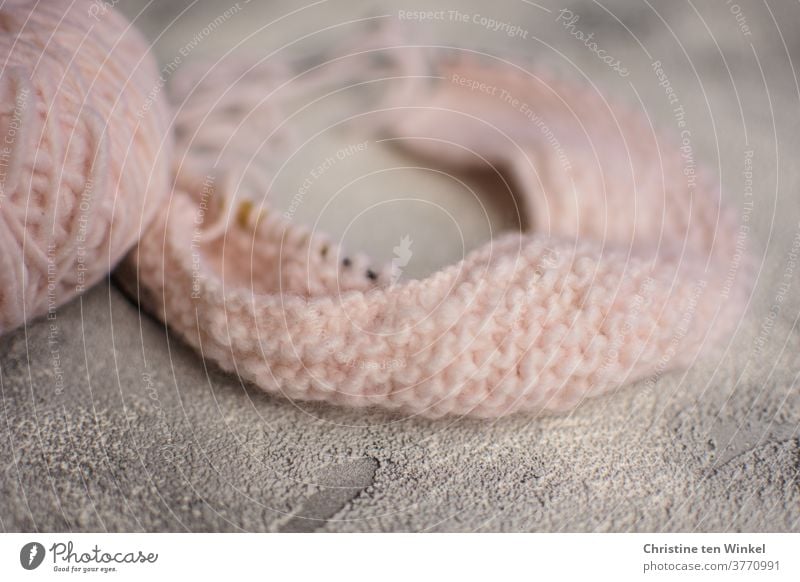 Knitting for the autumn / winter. Pink ball of wool and started knitting on a light grey background with shallow depth of field knitwear Handcrafts Autumn