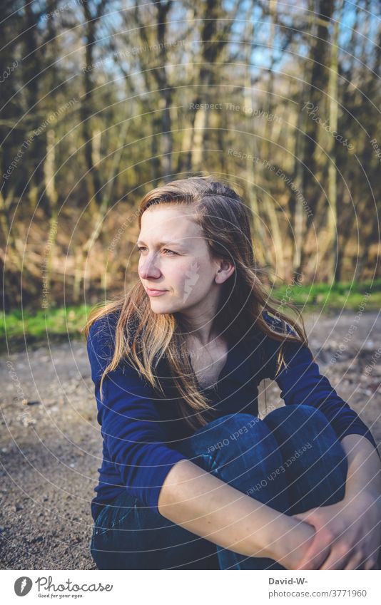 pretty natural woman sits on the floor and looks friendly to the side Blonde youthful naturally Smiling Attractive Sunlight Autumn Forest