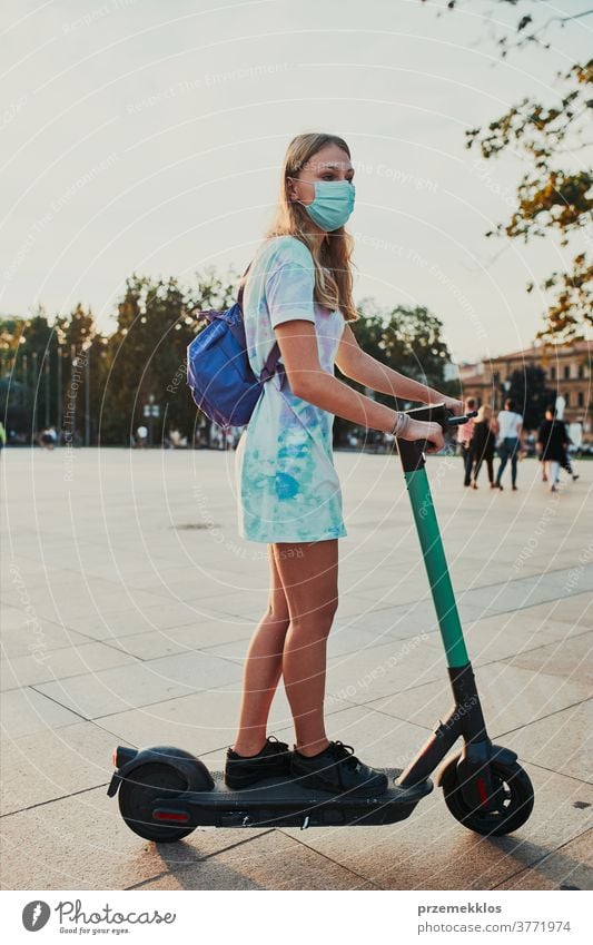 Young woman riding an electric scooter in the city center active authentic candid communication contemporary drive driving e-scooter eco ecological electricity