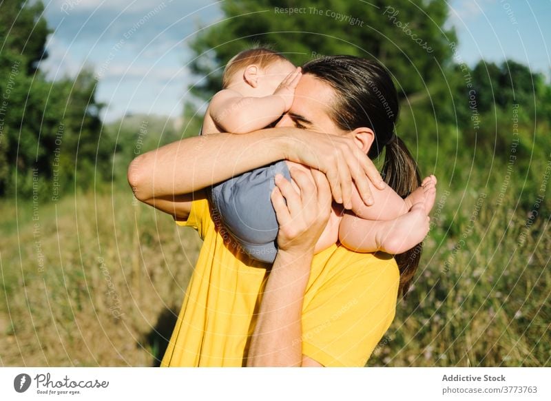 Young man playing with toddler in park father child together summer having fun adorable idyllic innocent weekend kid little enjoy relax childhood happy cheerful