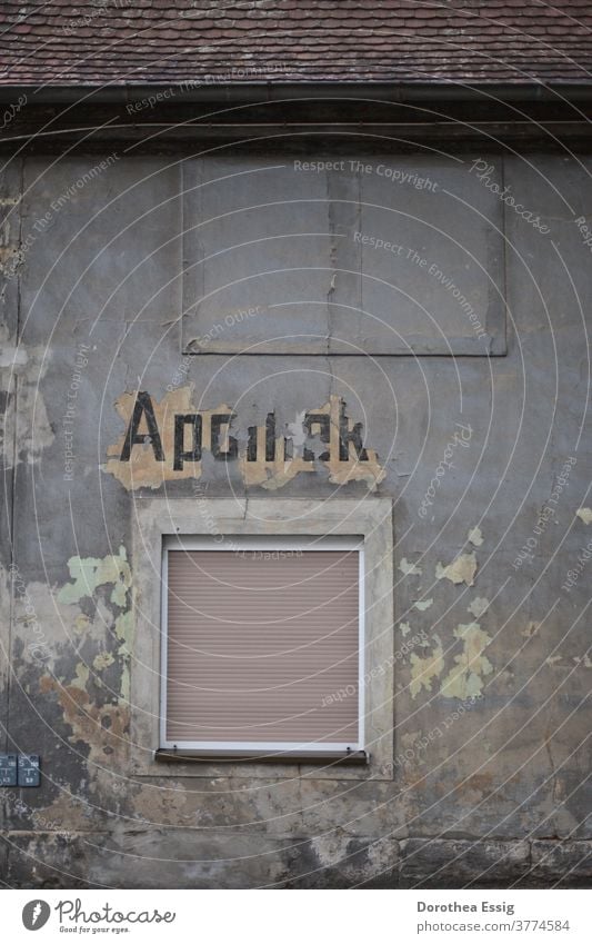 Faded lettering - "Pharmacy" on the wall of the house Decline Building Old Broken Wall (barrier) Facade Window Transience house wall Colour photo Subdued colour