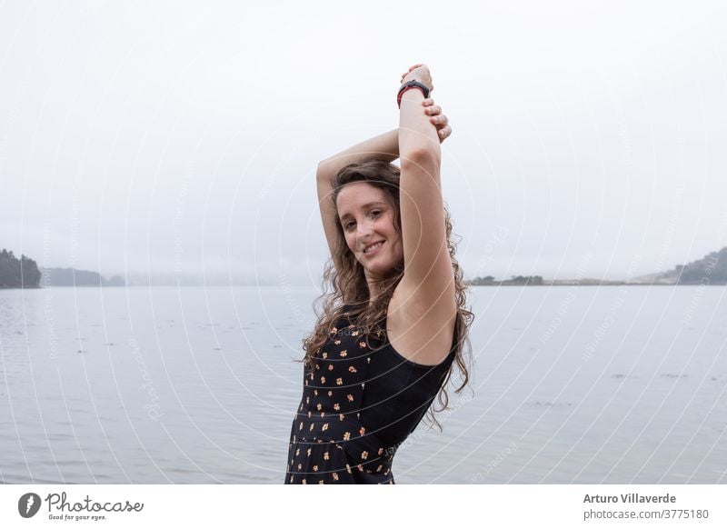 young girl posing with raised arms with the sea in the background on a cloudy day women youthful Ocean Spain Beauty & Beauty Fashion Beach Water Sky Woman