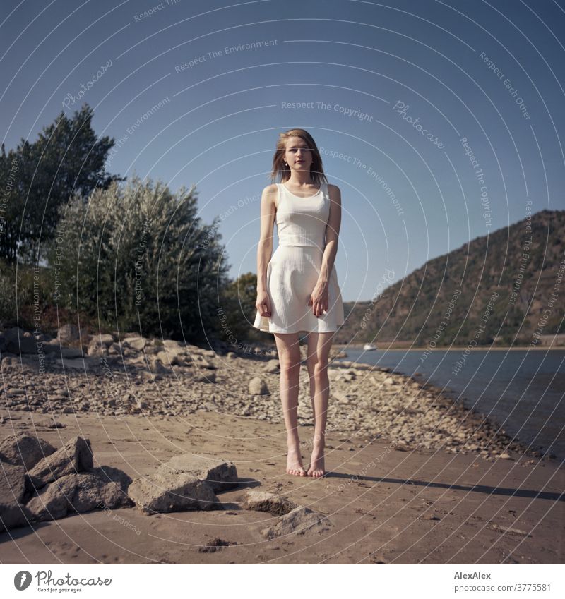 Analogue portrait of a young, barefoot woman standing on the banks of the Rhine Woman Young woman Slim already athletic Blonde youthful red blonde hair look see