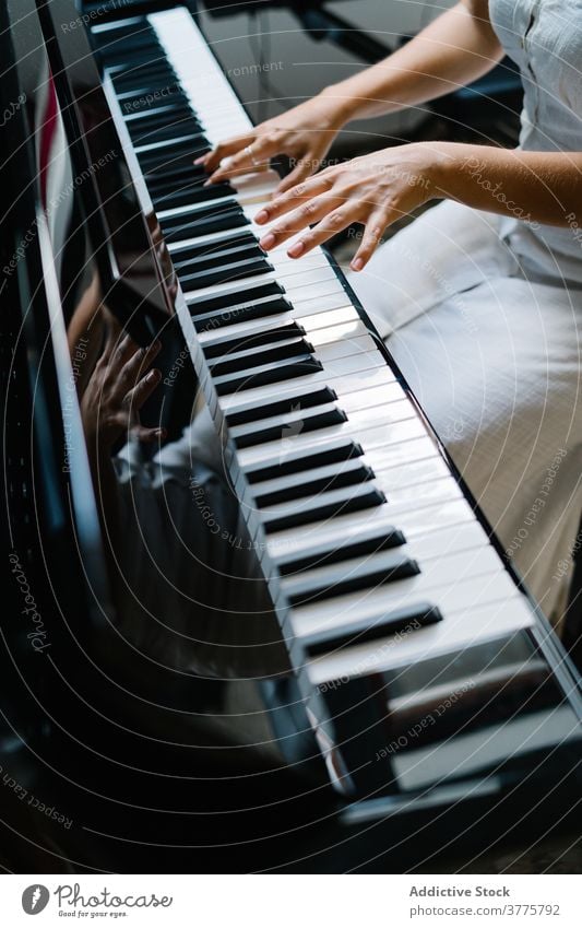 Crop woman playing piano at home musician sound melody rehearsal practice instrument female entertain apartment artist acoustic song hobby skill relax weekend