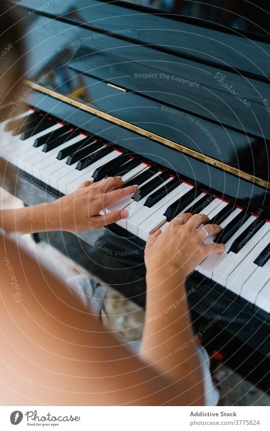 Woman playing piano in living room music musician woman rehearsal talent skill creative melody ethnic female modern apartment song perform sound entertain sit