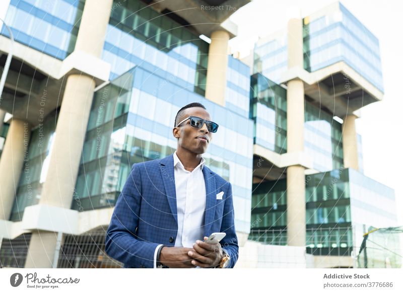 Serious businessman standing in downtown entrepreneur office building suit determine using male ethnic black african american glass formal manager project