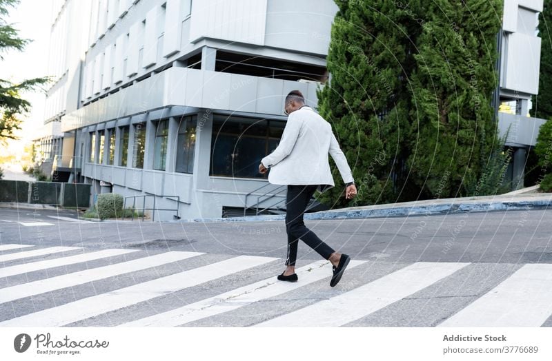 Stylish black businessman crossing road in city crosswalk entrepreneur style classy trendy male ethnic african american outfit manager professional contemporary