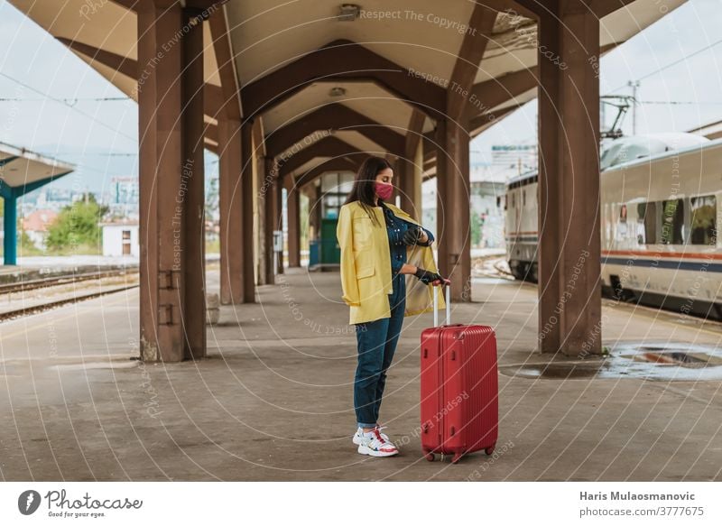 Woman with mask and travel bag waiting on public train station adult attractive baggage beautiful business caucasian city coronavirus covid-19 female journey