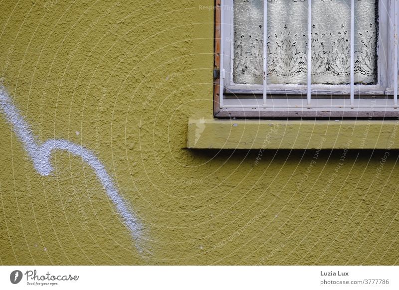 A yellow house wall, an old window with nostalgic curtain and a gracefully curved graffiti Yellow Old Window Grating window grilles Curtain