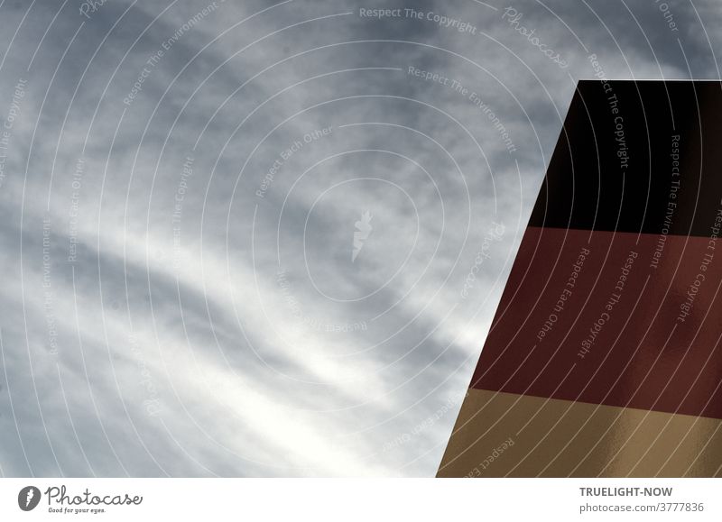 Vital | unity. Public stele in German national colours in front of a pale, slightly cloudy sky is to draw the people's attention to the Day of German Unity and the celebrations and speeches on it