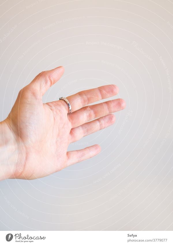 Extended female hand with open palm extended gray wall background help ring abstract give hold out woman closeup gesture offer show caucasian assitance inviting