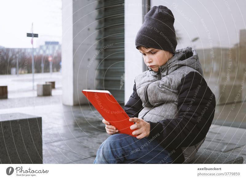 young boy looking at tablet pc computer with frustrated look on his face child kid play game technology little people digital internet childhood lifestyle