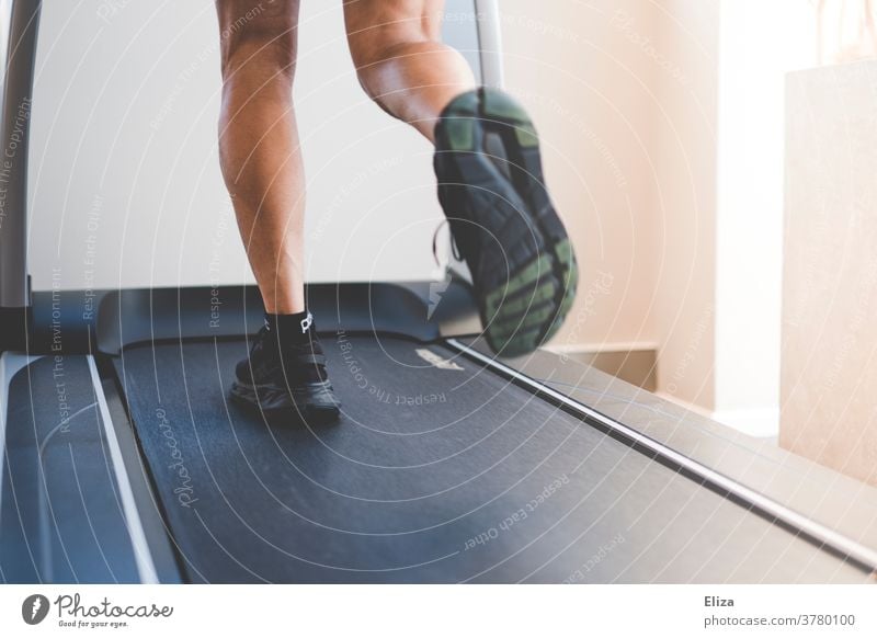 A man runs on a treadmill in the gym. Detail of the legs in motion. Moving pavement Walking Jogging Fitness centre Sports workout Athletic Fitness studio Legs