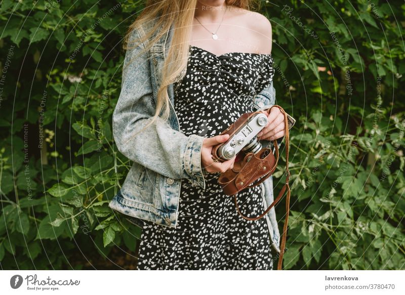 Closeup of woman's hands holding old vintage film camera, selective focus shoot professional photographer hobby female lens casual traveler activity shooting