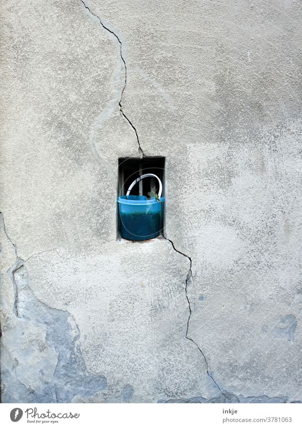 old bucket in front of small window in old facade with crack Colour photo Bucket Blue Crack & Rip & Tear Facade Copy Space Middle Gloomy Diagonal Plaster Gray