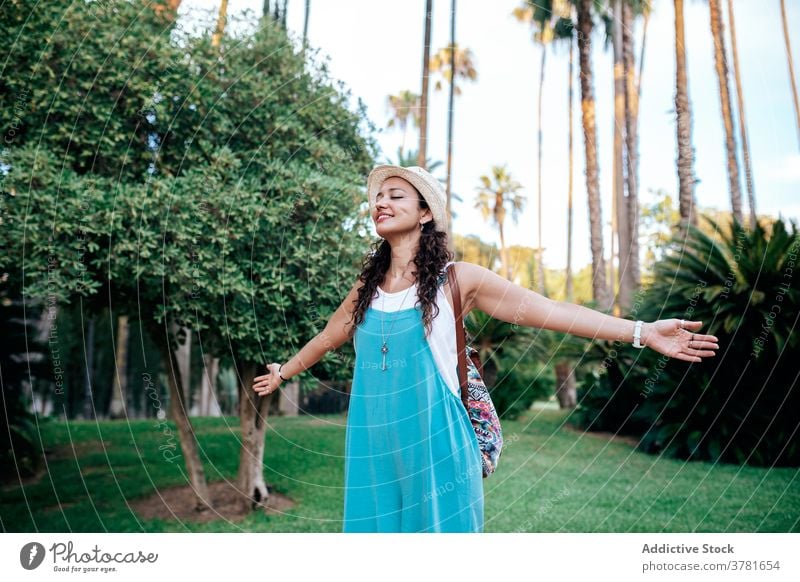 Carefree woman standing in tropical park carefree travel wanderlust enjoy vacation dreamy freedom female summer traveler relax holiday exotic rest journey