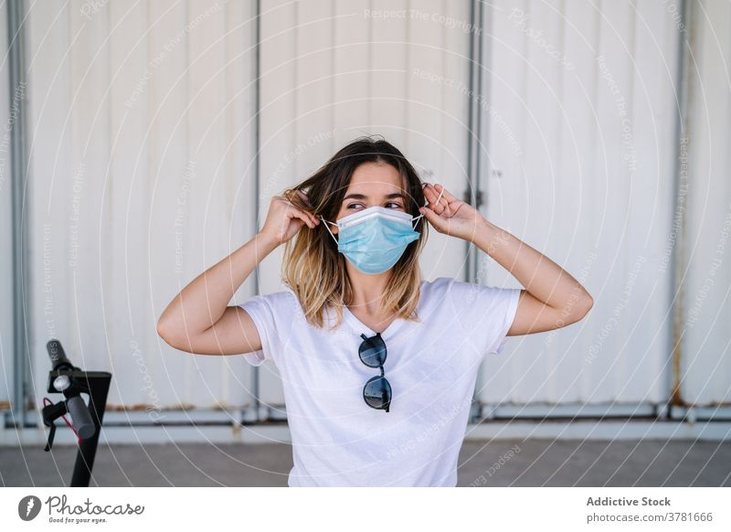 Female teenager in protective mask standing near electric scooter woman covid coronavirus rider transport urban vehicle new normal serious alternative