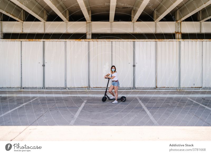 Female teenager in protective mask standing near electric scooter woman covid coronavirus rider transport urban vehicle new normal serious alternative