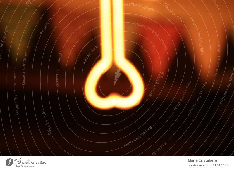 Heart shape neon light that is blurred on purpose to show concept of love, social distancing, self isolation and mental health during the quarantine due to the covid-19 outbreak