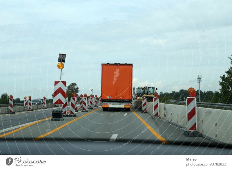 A truck drives through a construction site on the highway building road business car people industrial industry safety transport transportation vehicle work