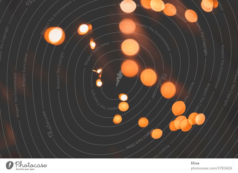 Light points of a chain of lights in the dark. Christmas lights. Fairy lights Christmas fairy lights light points Orange Abstract clearer warm Night Illuminate