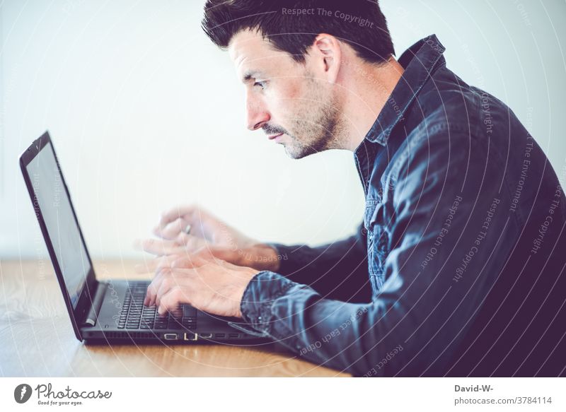 Man types on his laptop with lightning-fast fingers Typing swift Speed concentrated labour Desk home office frantic time pressure Success