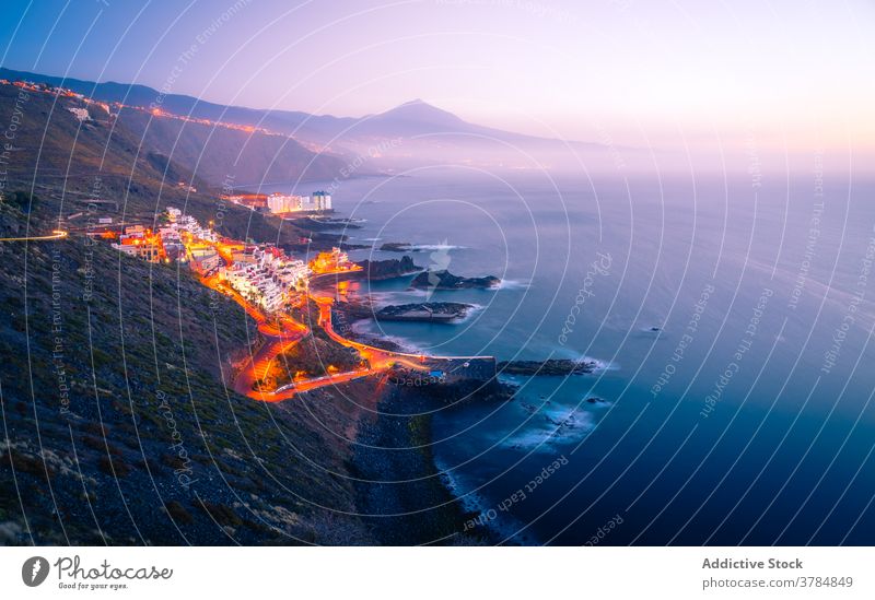 Amazing scenery of coastal city at sunset cityscape road traffic light sea mountain illuminate evening canary islands spain tenerife seashore rocky transport